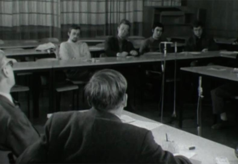 Theodor Eschenburg spricht über politische Filmdokumente aus den Jahren 1930-1933, Tübingen 1970. IWF (Göttingen), 1975. https://doi.org/10.3203/IWF/G-151, showing the scene in the classroom. From behind, we see Eschenburg on the left and Karl-Friedrich Reimers on the right. Courtesy of the TIB Hannover, cc-3.0