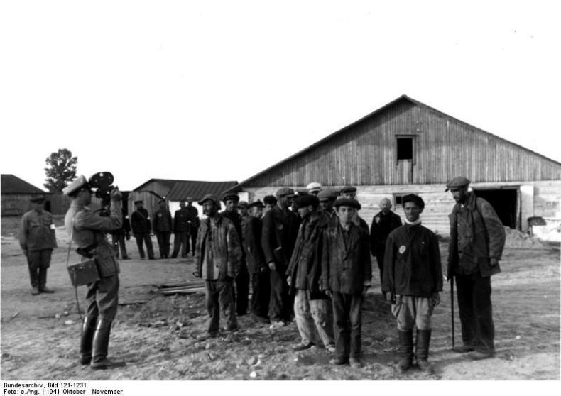 An unidentified PK or police cameraman filming Jewish prisoners in or near Minsk, autumn 1941. The footage is lost. This photo is part of the Adolf von Bomhard collection at Bundesarchiv, indicating it may have been taken by a police photographer. Bundesarchiv, Bild 121-1231.