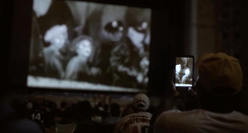 An audience member films the ‘resurrected’ screen at Cine Marrocos